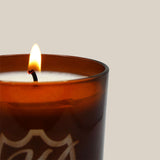 lit fall/winter candle in branded vessel
