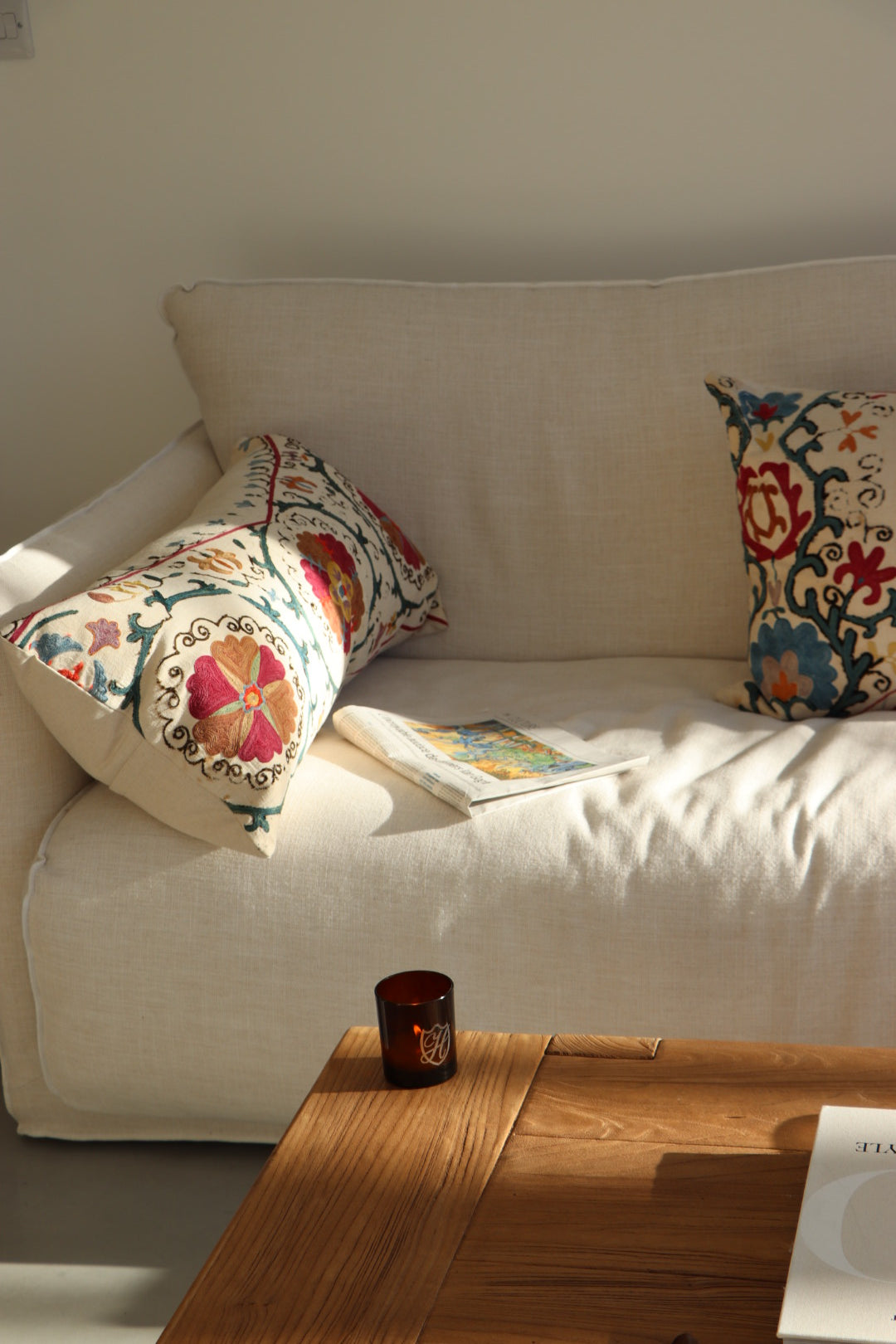 Cream sofa with wooden coffee table with glass candle and flame