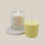 lit spring sakura candle and vessel n a marble slab with unlit refill